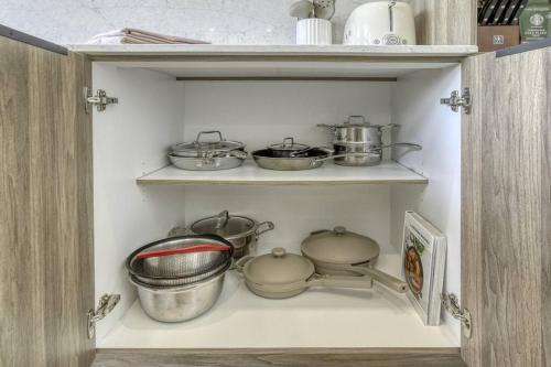 a shelf with pots and pans in a kitchen at Ultra Luxurious Modern Oasis Private Spa Sauna in La Conception