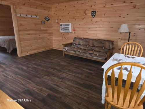 a living room with a couch and a table at Letchworth Valley Campground Cabins in Bliss
