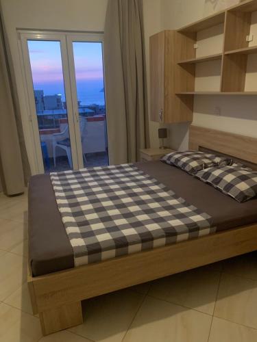 a large bed in a room with a window at Apartments Nurkovic in Dobra Voda