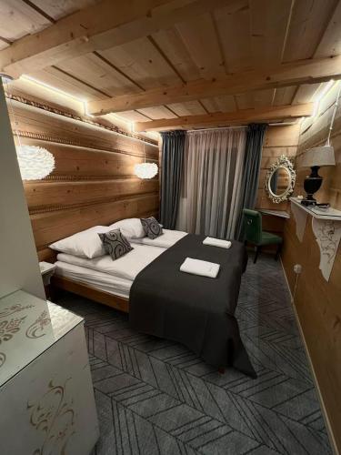 a bedroom with a large bed in a wooden room at Chałpa z bali in Zakopane