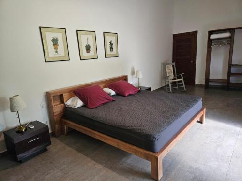 a bedroom with a bed with two red pillows at Casa Shambala B&B in Las Terrenas