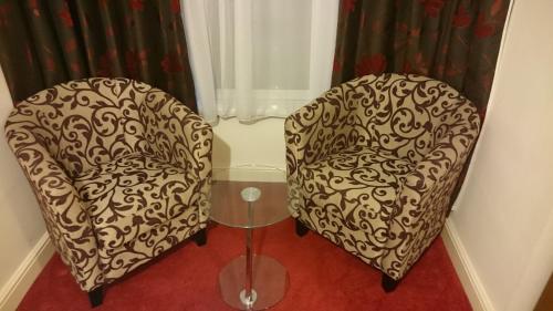 two chairs sitting in a room with curtains at Gateway Express in Newport