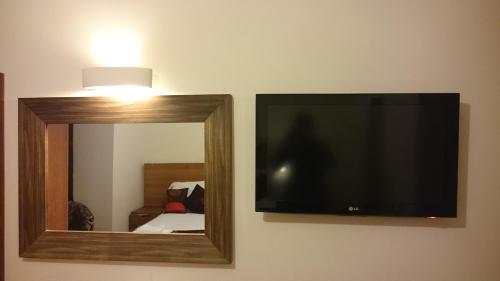 a flat screen tv on a wall with a mirror at Gateway Express in Newport