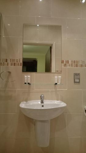 La salle de bains est pourvue d'un lavabo blanc et d'un miroir. dans l'établissement Gateway Express, à Newport