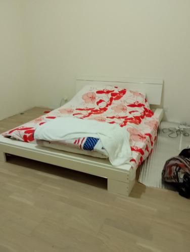 - un lit blanc avec une couverture rouge et blanche dans l'établissement Gite la roche Chalais, à La Roche-Chalais