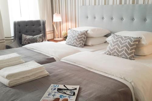 a bedroom with two beds and a chair at Flores Guest House in Lisbon