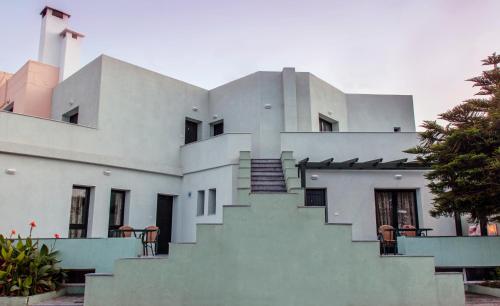 a white building with stairs on the side of it at Minos Apartments & Studios in Sitia