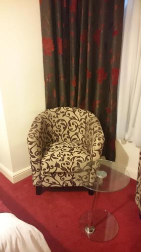 uma cadeira sentada num quarto com uma mesa de vidro em Gateway Express em Newport