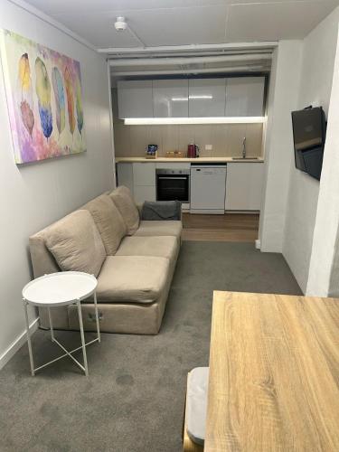 a living room with a couch and a kitchen at Alpine Gables in Jindabyne