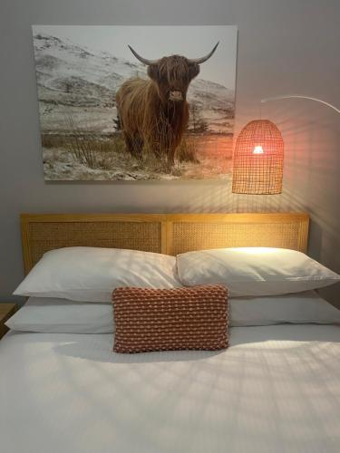a bed with a picture of a bull on the wall at Tranquility in Oberon