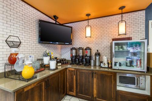 Best Western Premier Helena Great Northern Hotel في هيلينا: بار مع ثلاجة وجهاز تلفزيون على الحائط