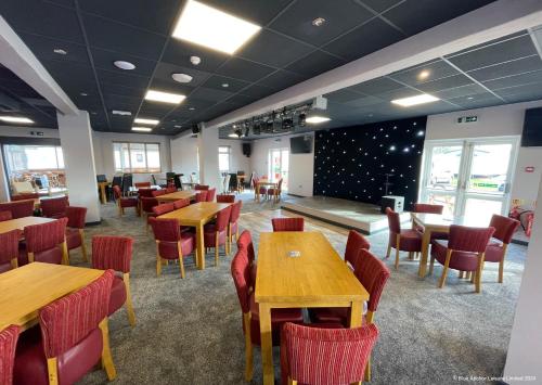 a dining room with wooden tables and chairs at Towervans Holiday Park in Mablethorpe
