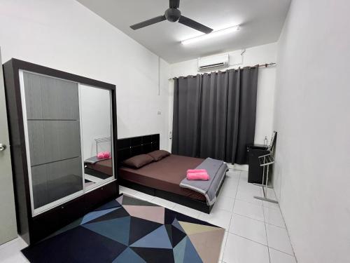 a bedroom with a bed with a mirror and a ceiling fan at Meen Homestay in Muadzam Shah