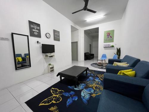 a living room with a blue couch and a table at Meen Homestay in Muadzam Shah