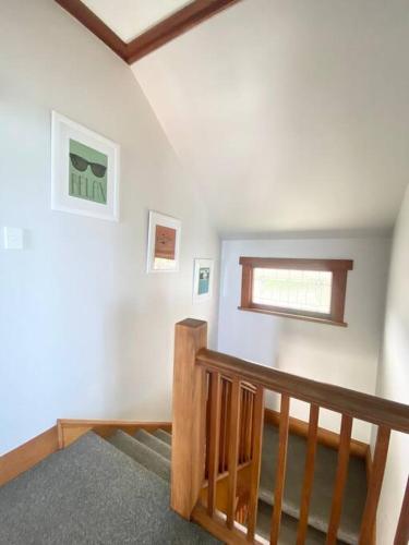 a room with a wooden staircase with a window at Spectacular View atop Napier Hill - Space for all! in Napier