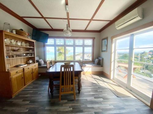 a kitchen with a wooden table and a large window at Spectacular View atop Napier Hill - Space for all! in Napier
