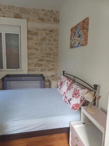 a bedroom with a bed and a brick wall at casa zervos - Abode of Light in Loutraki
