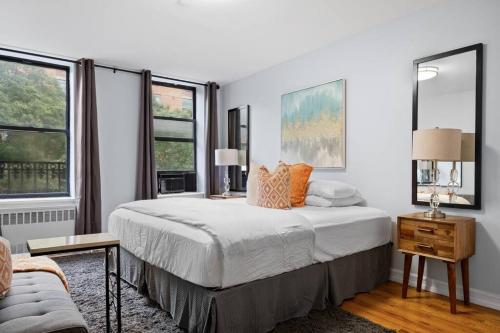 a white bedroom with a bed and two windows at The Lenox in New York