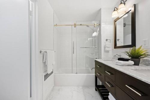 a white bathroom with a shower and a sink at The Lenox in New York