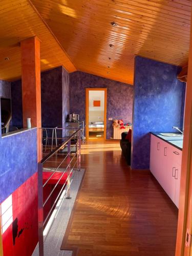a large room with a kitchen with blue and red walls at DUPLEX LUMINOSO Y TRANQUILo in El Pont de Vilumara