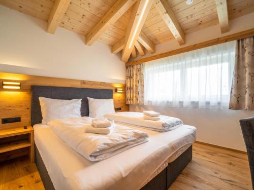 ein Schlafzimmer mit einem großen Bett mit zwei Handtüchern darauf in der Unterkunft Chalet Pettneu am Arlberg - Top 4 in Pettneu am Arlberg