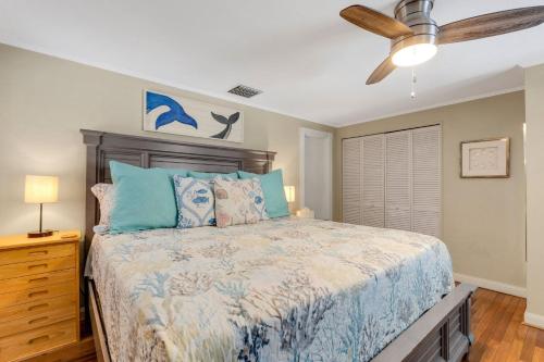 a bedroom with a bed and a ceiling fan at Water View & Heated Pool - Steps to Sand, Bayview Beauty B-5 in Clearwater Beach