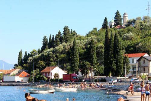 a group of people in the water at a beach at Villetta Monte - 3 minutes walk from the sea in Herceg-Novi