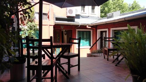 a table and chairs on a patio with an umbrella at Hotel Rivera in Colonia del Sacramento