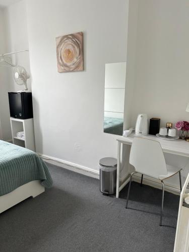 a bedroom with a bed and a desk and a table at LORD MERIT GUEST HOUSE KING'S CROSS GRAYS INN ROAD in London