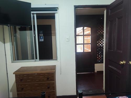 a room with a door and a dresser and a mirror at Hostal Fernanda in Santa Cruz