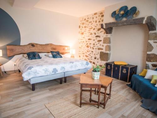 una camera con un grande letto e un divano blu di Longère rénovée avec charme, 5 chambres, grand jardin, proche du village, idéale pour 15 pers. - FR-1-410-355 a Saint-Léonard-des-Bois