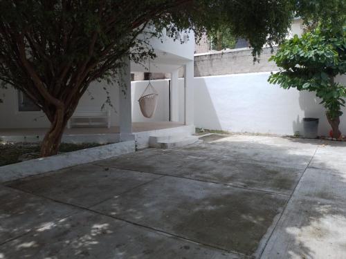 ein weißes Gebäude mit einem Baum und einer Tür in der Unterkunft Casa Fefe Huatulco in Tangolunda