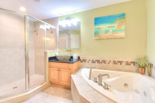 a large bathroom with a tub and a shower at Bayway Luxury Waterfront Townhome & Pool in Clearwater Beach
