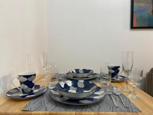 a table with blue and white dishes and wine glasses at Casa Bella at Sea Residences MOA in Manila