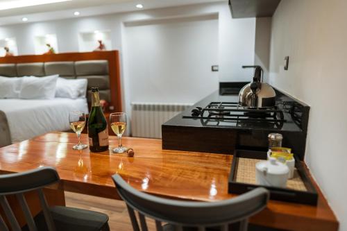 a kitchen with a stove and a table with wine glasses at San Blas Acogedor y Privado Studio C201 in Cusco