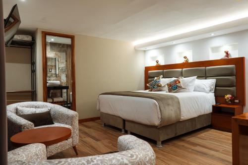 a bedroom with a large bed and a chair at San Blas Acogedor y Privado Studio C201 in Cusco