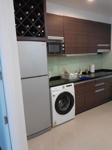 a kitchen with a washing machine and a refrigerator at Arisara place in Koh Samui 