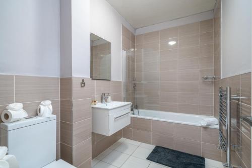 a bathroom with a sink and a toilet and a tub at Watford Junction 2 bedrooms Apartment, Free,Parking, Warner Bro nearby -15 mins to Central London in Watford