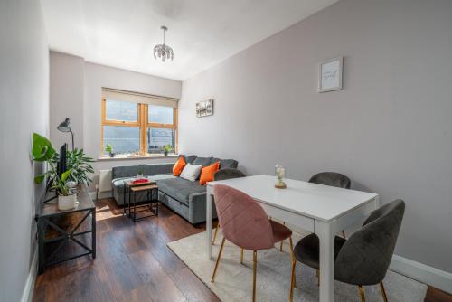 a living room with a couch and a table and chairs at Watford Junction 2 bedrooms Apartment, Free,Parking, Warner Bro nearby -15 mins to Central London in Watford