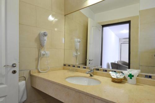 a bathroom with a sink and a mirror at Los Sauces Hotel & Spa in Villa Carlos Paz