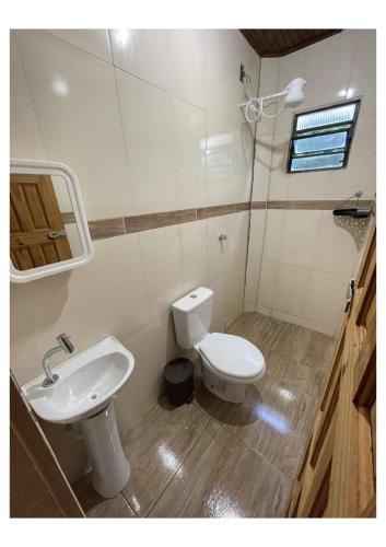 a bathroom with a toilet and a sink at Pousada Montanha Mágica in São Thomé das Letras