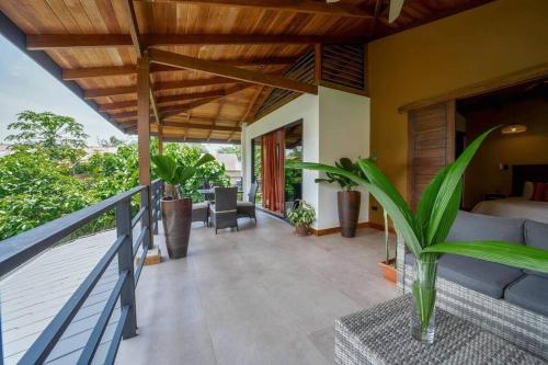 a balcony of a house with a bed and a couch at Modern Two Story Beach house in Puerto Viejo