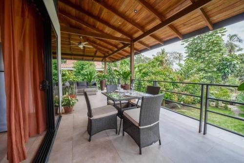 a patio with a table and chairs on a balcony at Modern Two Story Beach house in Puerto Viejo