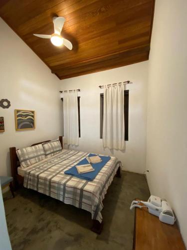 a bedroom with a bed and a ceiling fan at Pousada Caminho do Vale Guiné in Mucugê