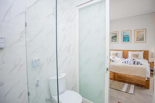 a bathroom with a shower with a toilet and a bed at Alas Villa - 3 Bedrooms Private Pool Villa in Nusa Lembongan