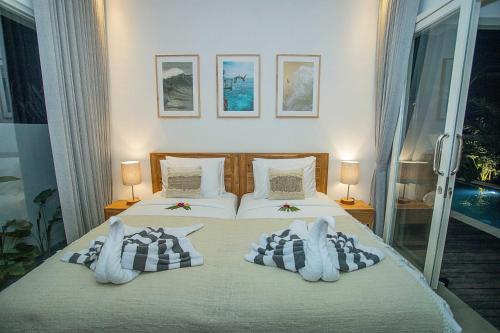 a bedroom with a bed with two pillows at Alas Villa - 3 Bedrooms Private Pool Villa in Nusa Lembongan