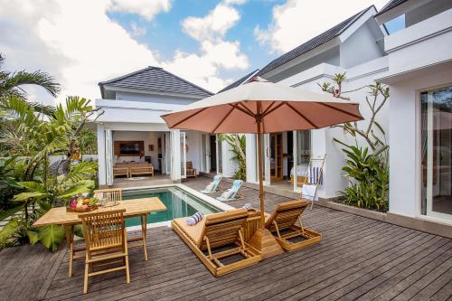 a patio with a table and chairs and an umbrella at Alas Villa - 3 Bedrooms Private Pool Villa in Nusa Lembongan