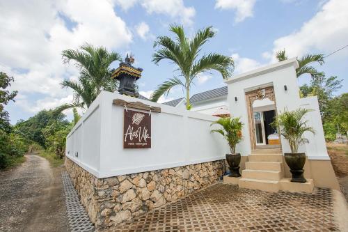 a white house with palm trees on a street at Alas Villa - 3 Bedrooms Private Pool Villa in Nusa Lembongan