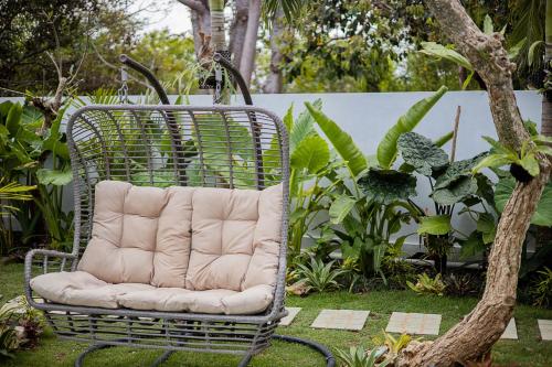 a rattan chair sitting in a garden at Alas Villa - 3 Bedrooms Private Pool Villa in Nusa Lembongan
