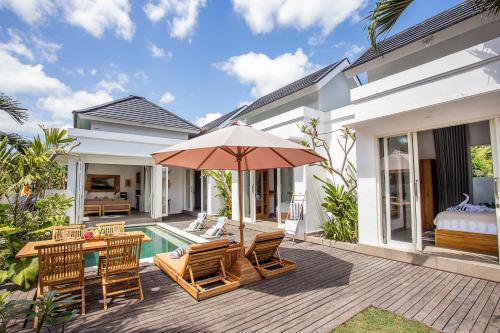a patio with a table and chairs and an umbrella at Alas Villa - 3 Bedrooms Private Pool Villa in Nusa Lembongan